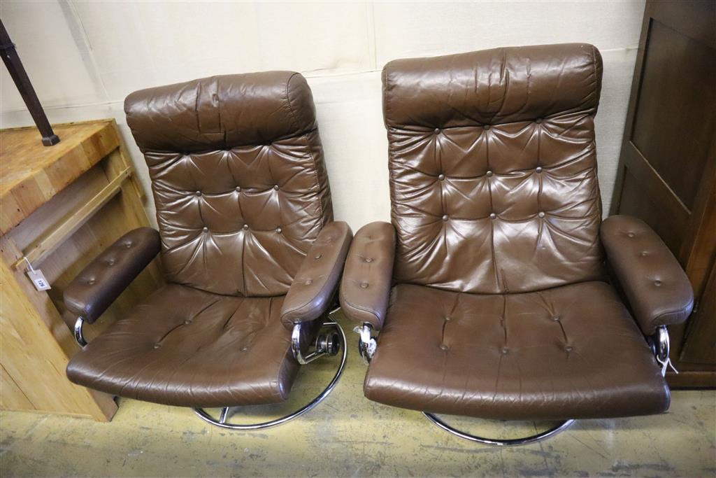 A pair of Erkones brown leather and chrome reclining armchairs